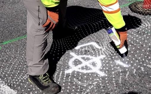 Worker spray painting ground